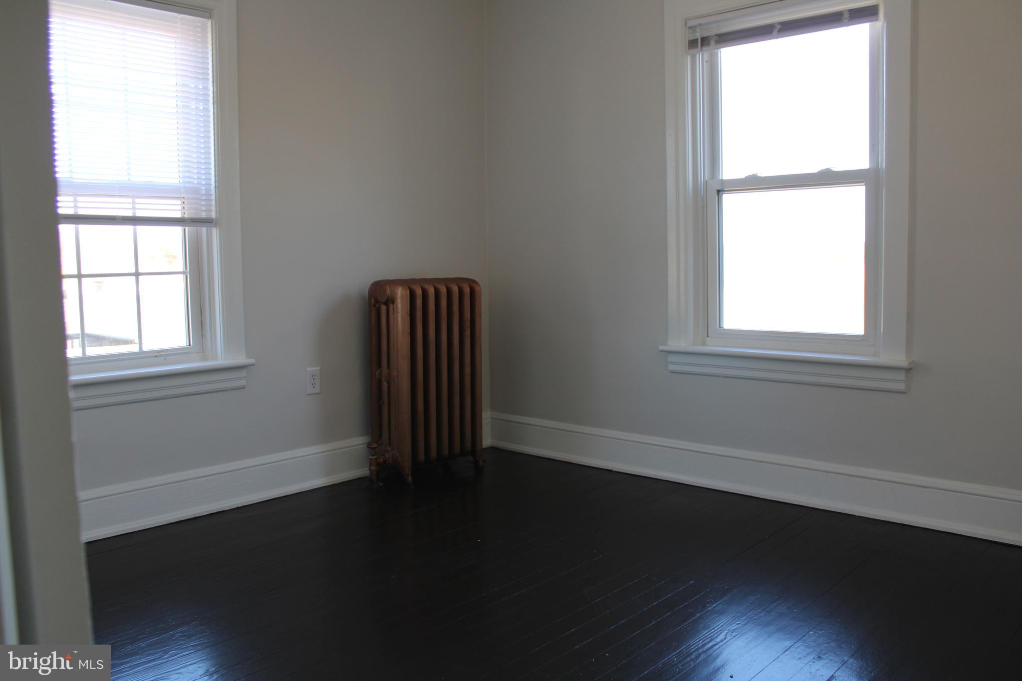 19332 Longmeadow Road Hagerstown, MD 21742 - Photo 12 of 21 an empty room with wooden floor and windows