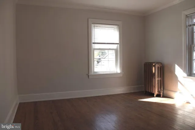 an empty room with wooden floor and a window