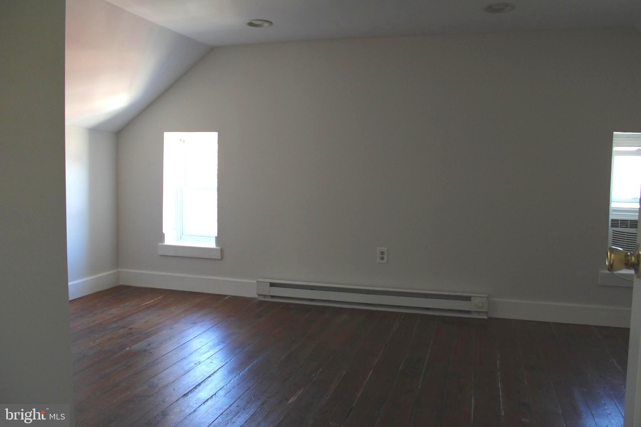 19332 Longmeadow Road Hagerstown, MD 21742 - Photo 16 of 21 an empty room with wooden floor and windows