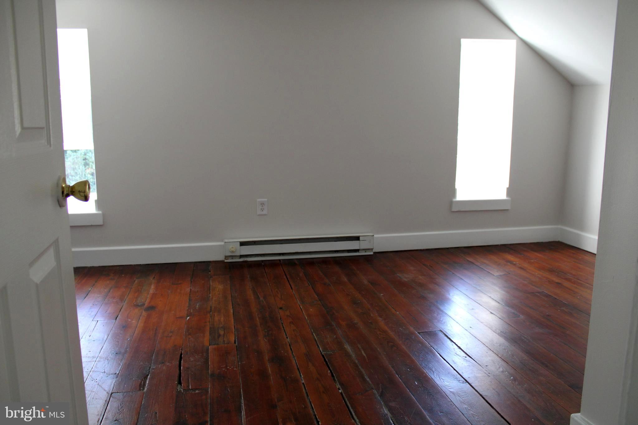 19332 Longmeadow Road Hagerstown, MD 21742 - Photo 19 of 21 an empty room with wooden floor and windows