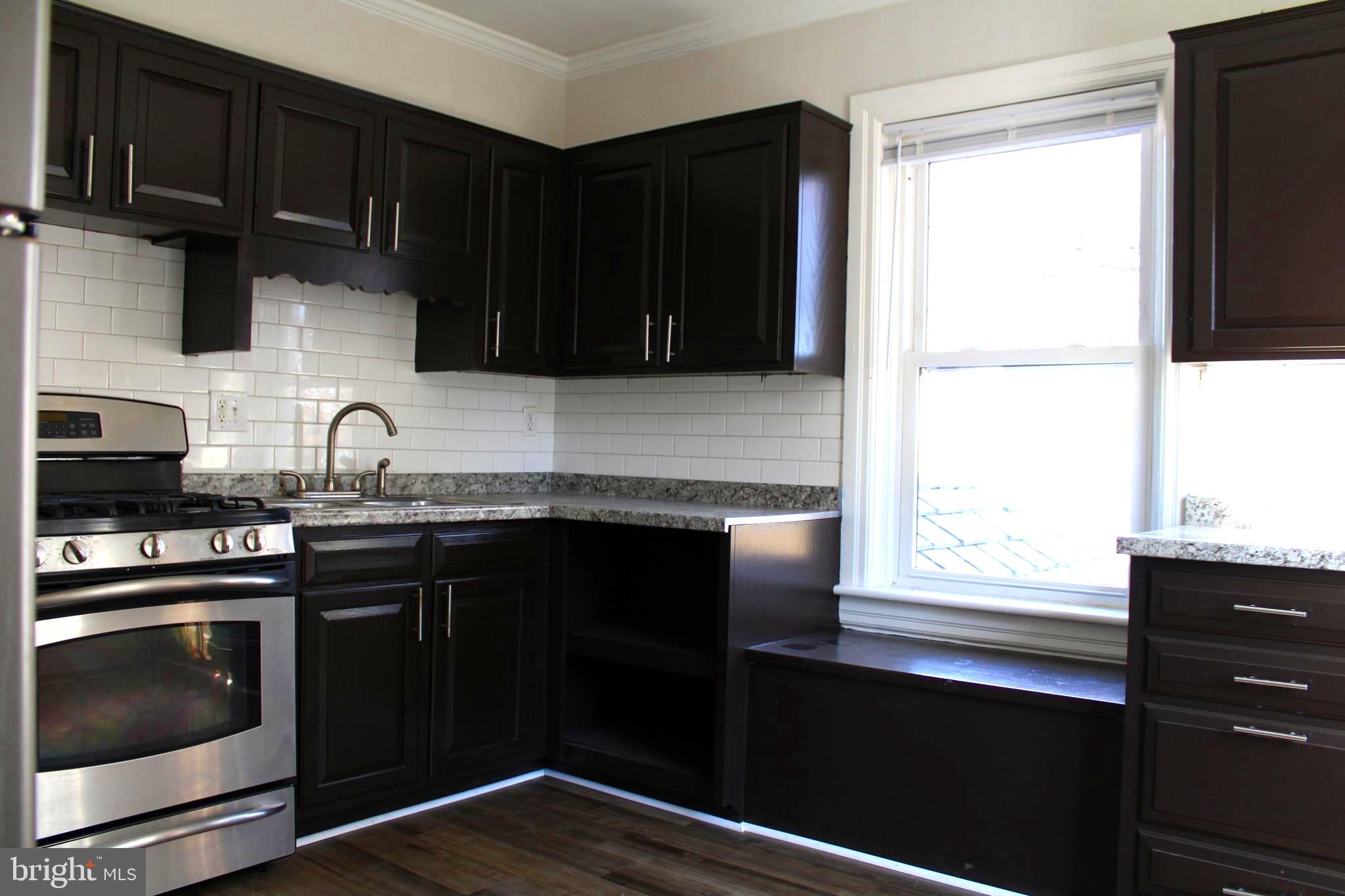 19332 Longmeadow Road Hagerstown, MD 21742 - Photo 6 of 21 a kitchen with granite countertop a stove a sink and a microwave