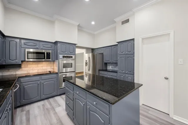 a kitchen with stainless steel appliances granite countertop a sink stove microwave and refrigerator