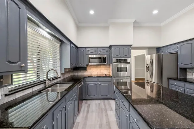 a kitchen with stainless steel appliances granite countertop a sink stove and refrigerator