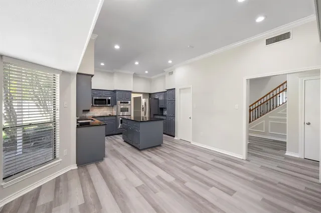 a kitchen with stainless steel appliances a refrigerator and wooden floor