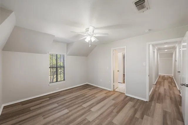 an empty room with windows and ceiling fan