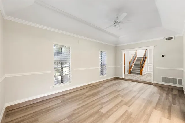 a view of an empty room with a window and wooden floor