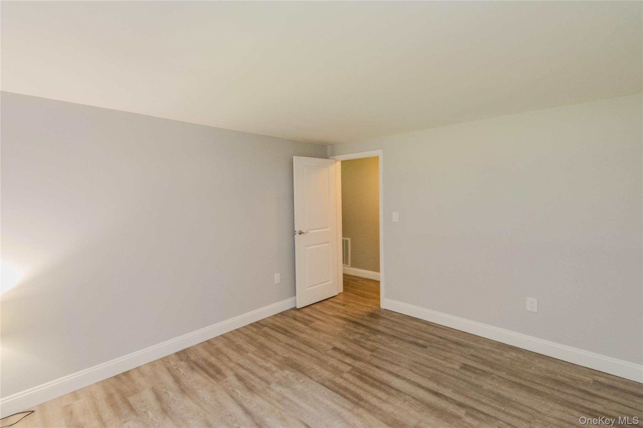 15 Van Dewark Road Middletown, NY 10941 - Photo 21 of 41 Interior room featuring light gray walls, wood-finish flooring, white baseboards, and a white interior door