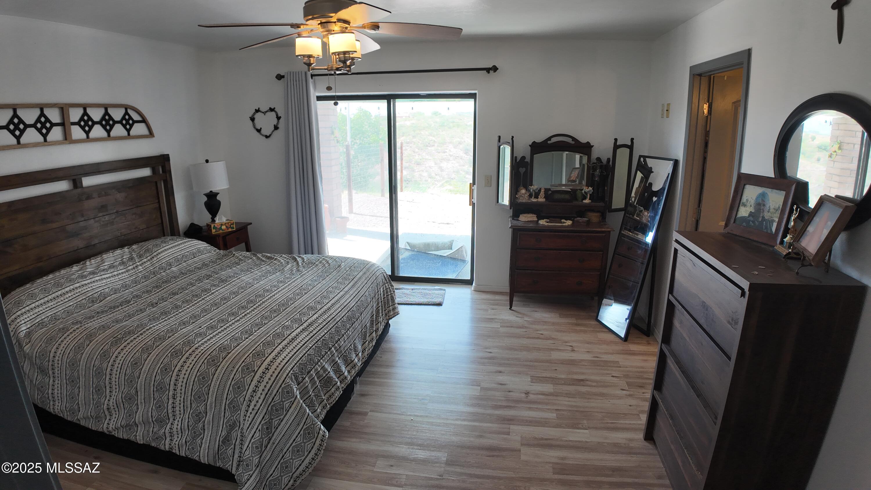 995 Jar Court Rio Rico, AZ 85648 - Photo 20 of 44 a bedroom with a bed a mirror on dresser and a chandelier