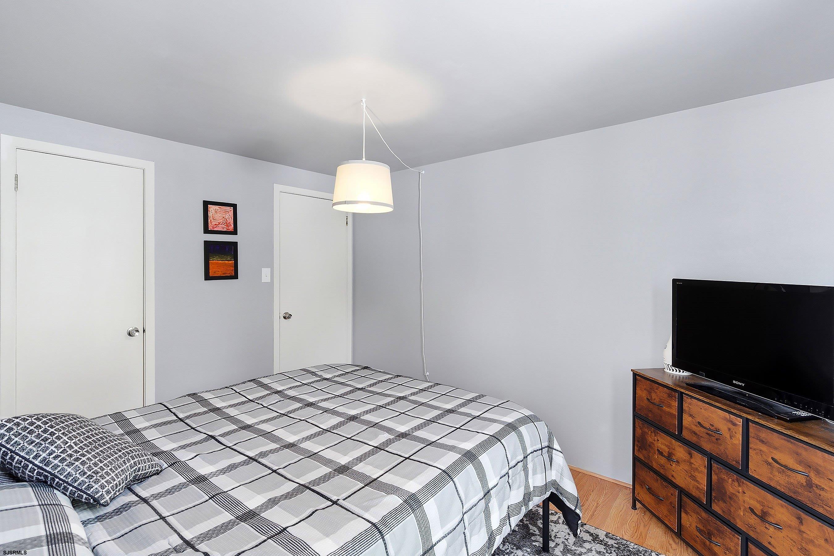 224 Meadow Ridge Road, Unit 224 Smithville, NJ 08205 - Photo 13 of 22 a bedroom with a bed and a flat screen tv