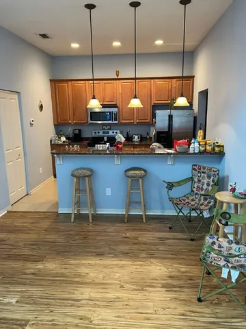 a kitchen with stainless steel appliances granite countertop a stove a sink and a wooden floors