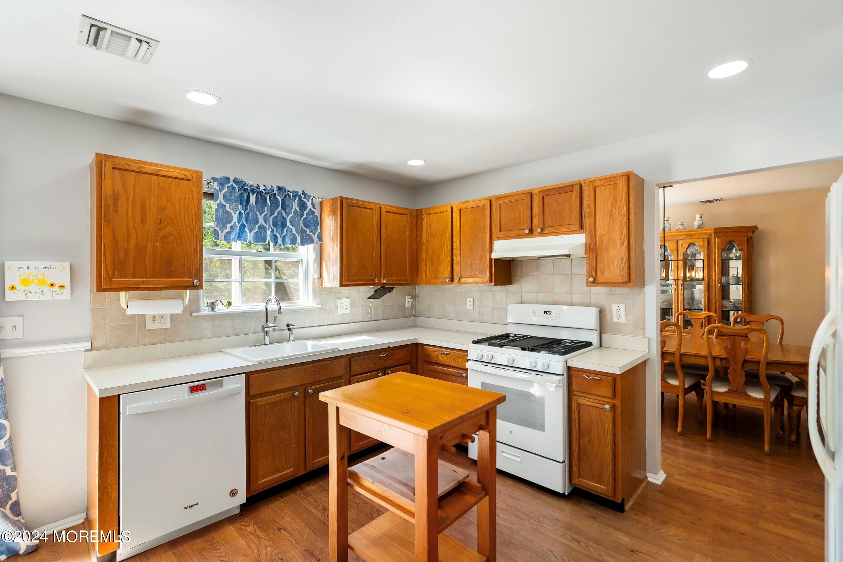 17 Glacier Drive Howell, NJ 07731 - Photo 14 of 43 a kitchen with a stove a sink a microwave a dining table and chairs