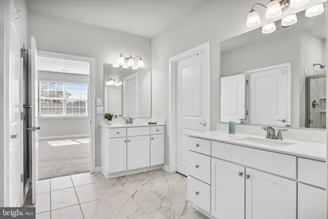 a bathroom with a double vanity sink mirror and