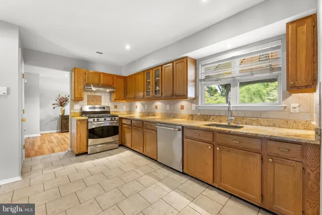 a kitchen with stainless steel appliances granite countertop a stove and a sink