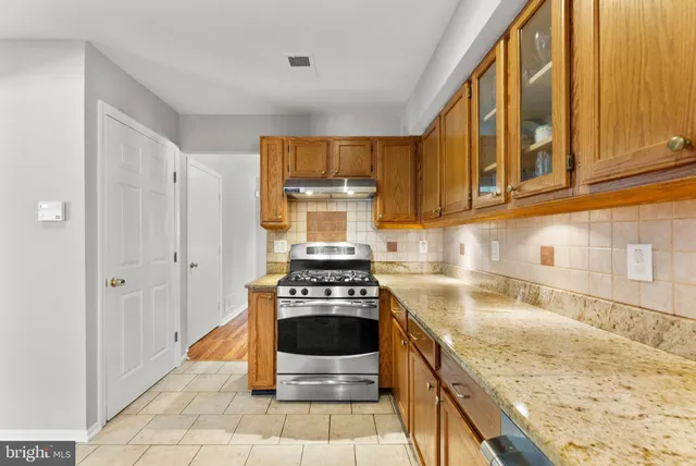a kitchen with granite countertop a sink cabinets and window