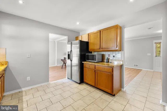 a kitchen with stainless steel appliances granite countertop a refrigerator and a stove top oven