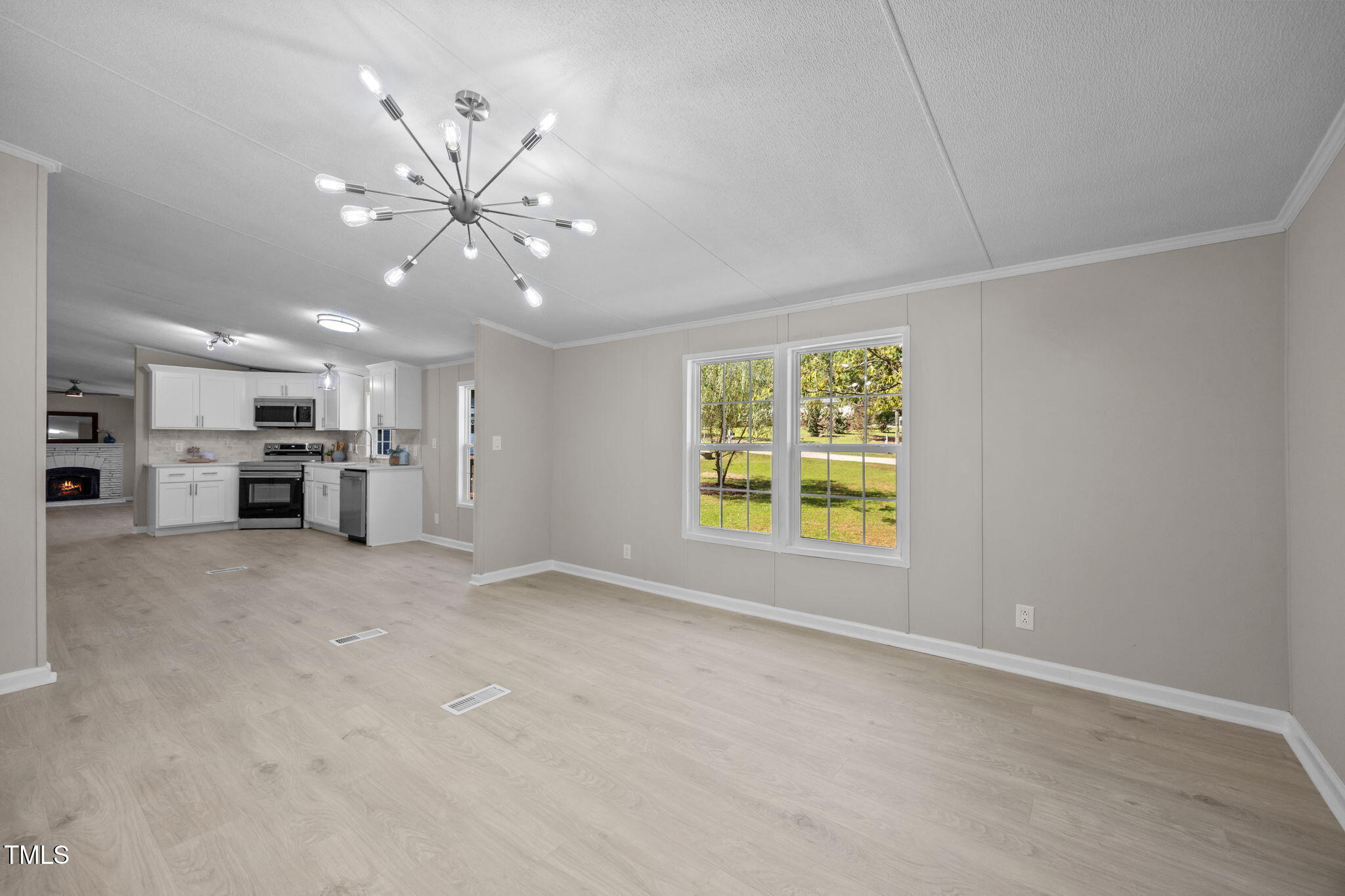 261 Ragland Lane Henderson, NC 27537 - Photo 12 of 58 a view of a kitchen with a stove cabinets a ceiling fan and wooden floor