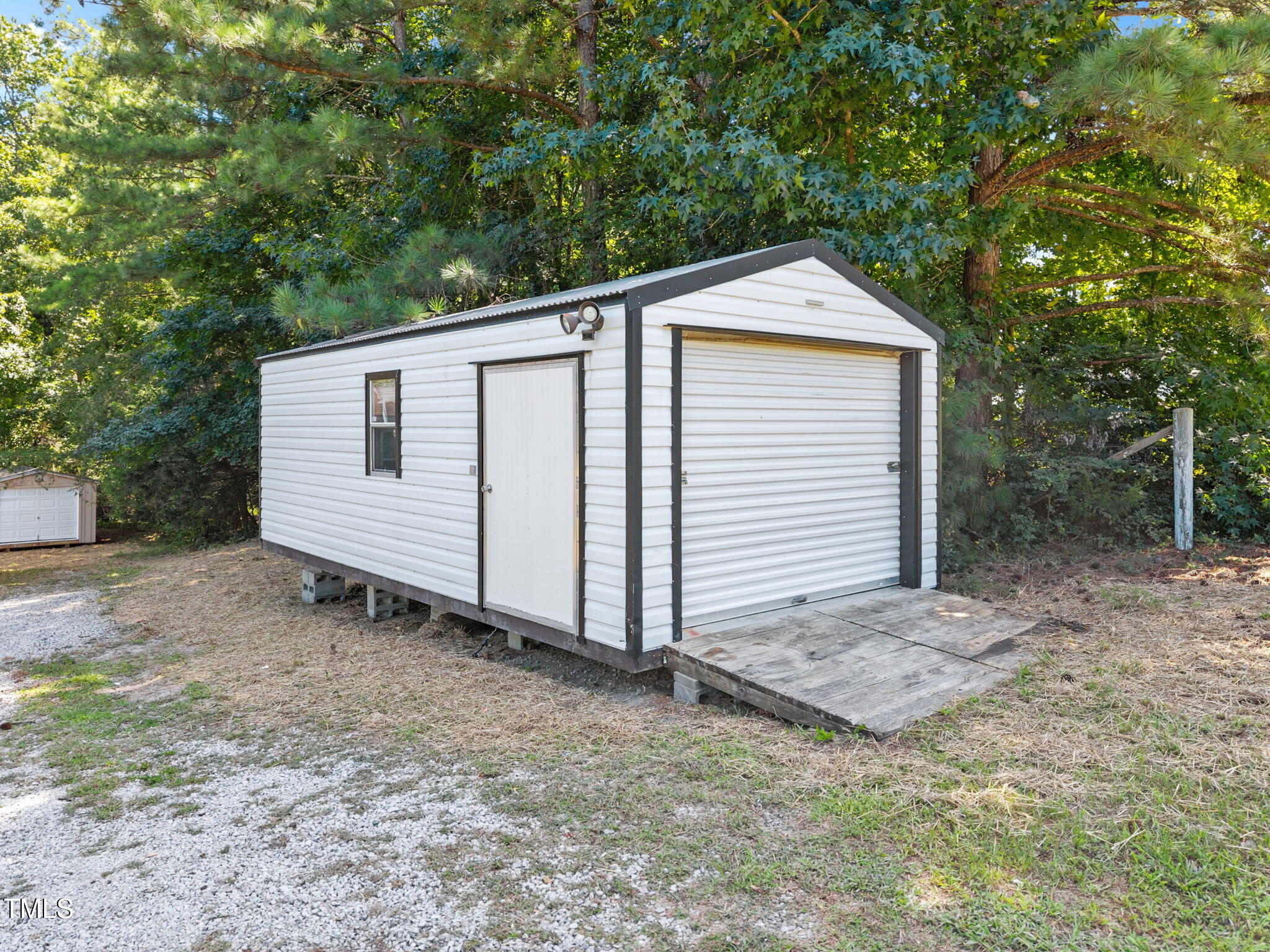 261 Ragland Lane Henderson, NC 27537 - Photo 44 of 58 a view of a small white house with a small yard and large tree