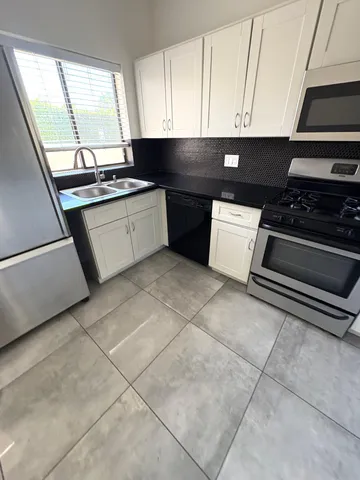 a kitchen with a stove a sink and a microwave