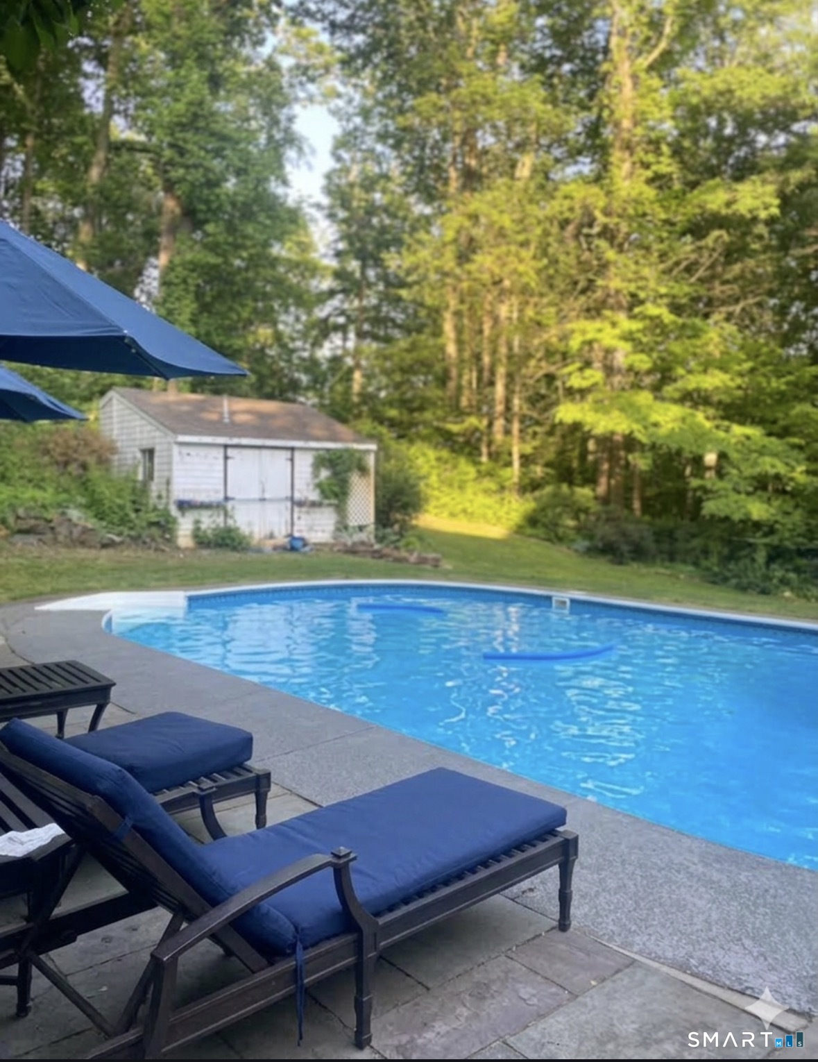 301 Old Norwalk Road New Canaan, CT 06840 - Photo 26 of 27 a view of a patio with lawn chairs under an umbrella