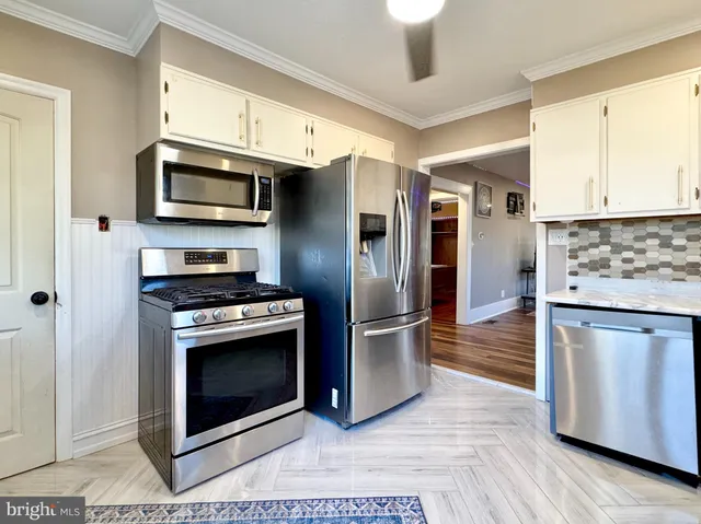 a kitchen with stainless steel appliances granite countertop a stove a refrigerator and a microwave