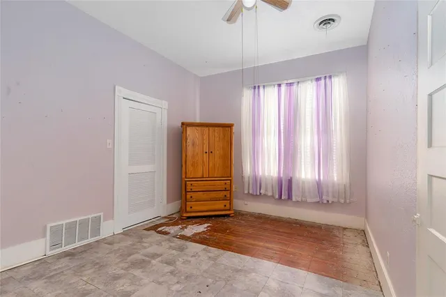 an empty room with closet and windows