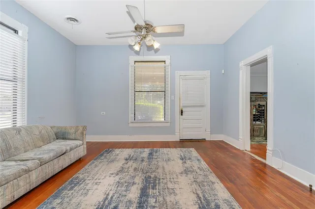 a view of an empty room with window and wooden floor