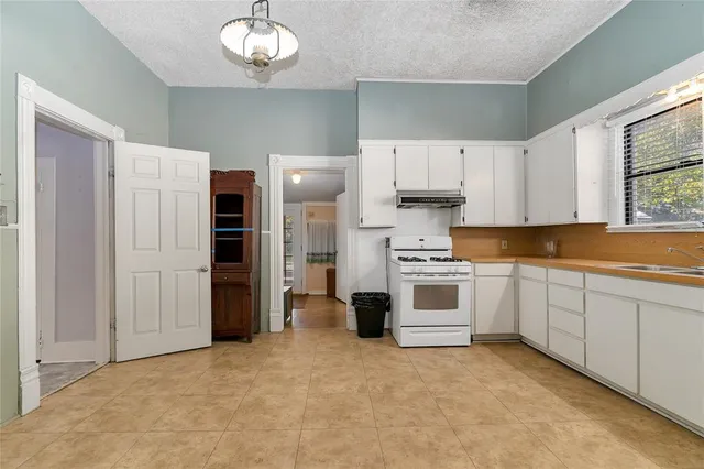 a kitchen with granite countertop white cabinets and white appliances