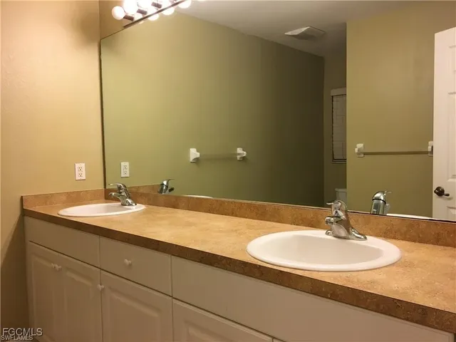 a bathroom with a double vanity sink and a mirror