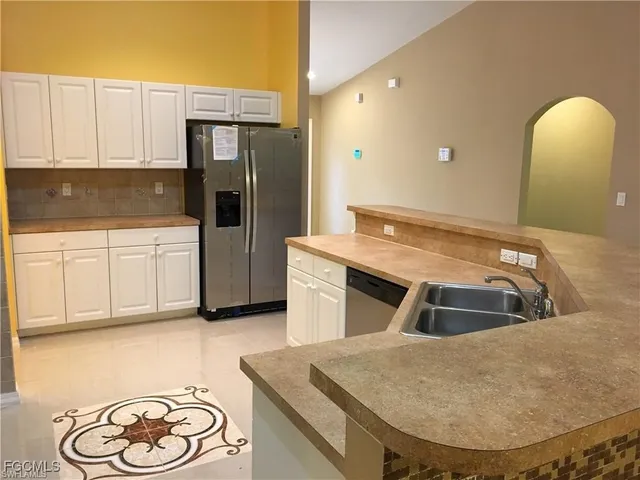 a kitchen with stainless steel appliances granite countertop a sink a stove and refrigerator