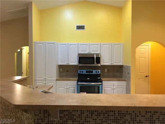 a kitchen with a sink appliances and cabinets