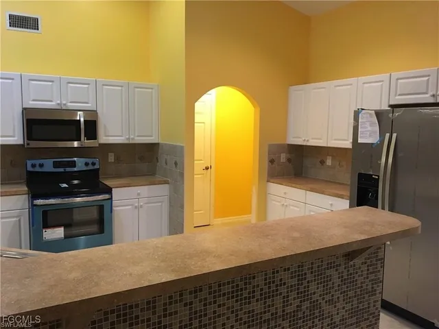 a kitchen with stainless steel appliances a stove a microwave and a refrigerator