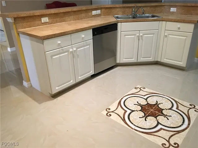 a kitchen with white cabinets and white appliances