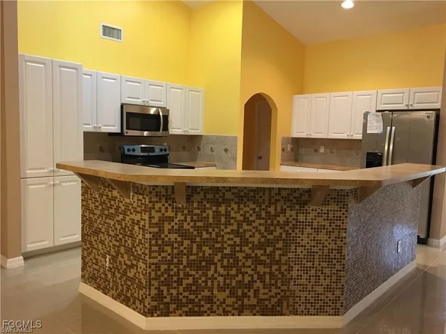 a kitchen with a sink a counter top space cabinets stainless steel appliances and a counter top space