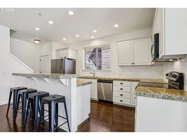 a kitchen with granite countertop a sink stainless steel appliances and cabinets