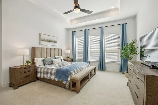 a bed sitting in a spacious bedroom next to a window and a lamp
