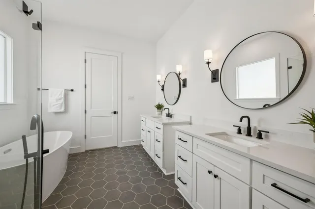 a spacious bathroom with a double vanity sink a mirror and a shower