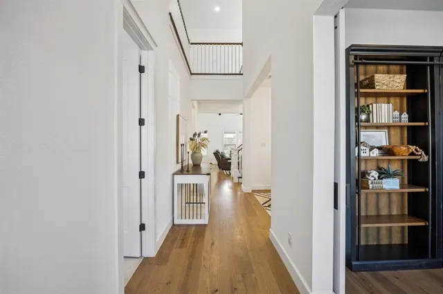 a view of a hallway with wooden floor and dining room