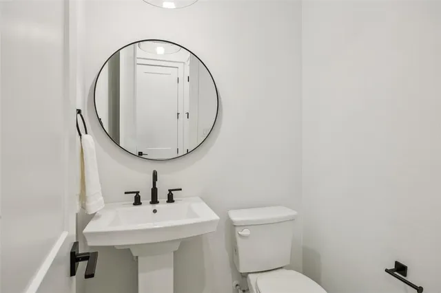 a bathroom with a toilet a sink and a mirror