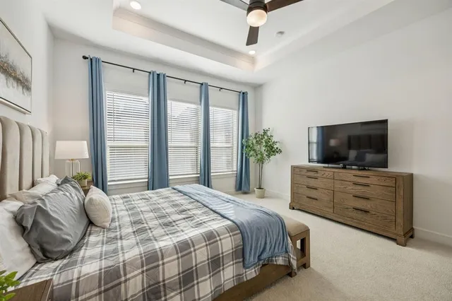 a bedroom with a bed television and a window