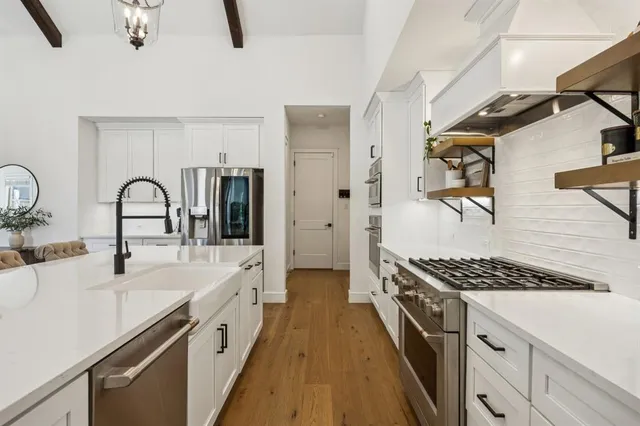 a kitchen with granite countertop a sink stove and cabinets