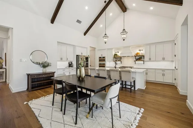 a view of a dining room and livingroom with furniture wooden floor and a rug