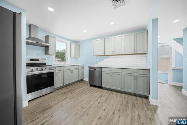 a kitchen with a white cabinets and wooden floor