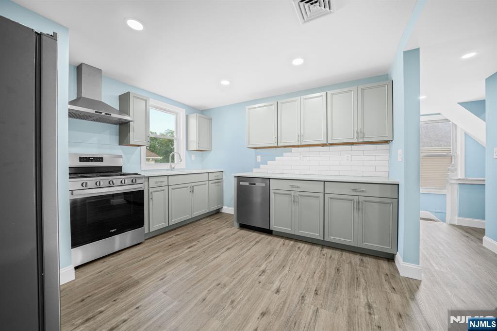 137 Prospect Place Rutherford, NJ 07070 - Photo 4 of 19 a kitchen with a white cabinets and wooden floor