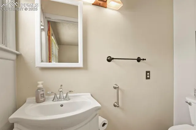a bathroom with a sink and mirror with toilet