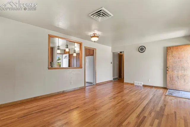 a view of an empty room with wooden floor