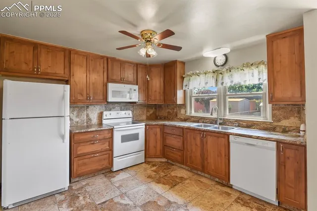 a kitchen with granite countertop a sink stainless steel appliances and cabinets