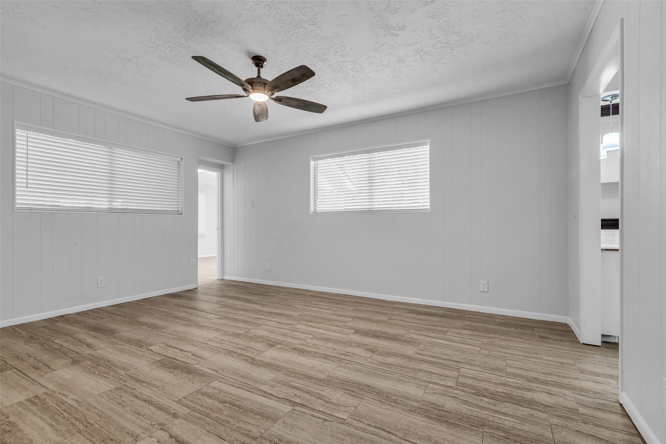 23311 Nichols Sawmill Road Hockley, TX 77447 - Photo 11 of 23 an empty room with wooden floor a ceiling fan and windows