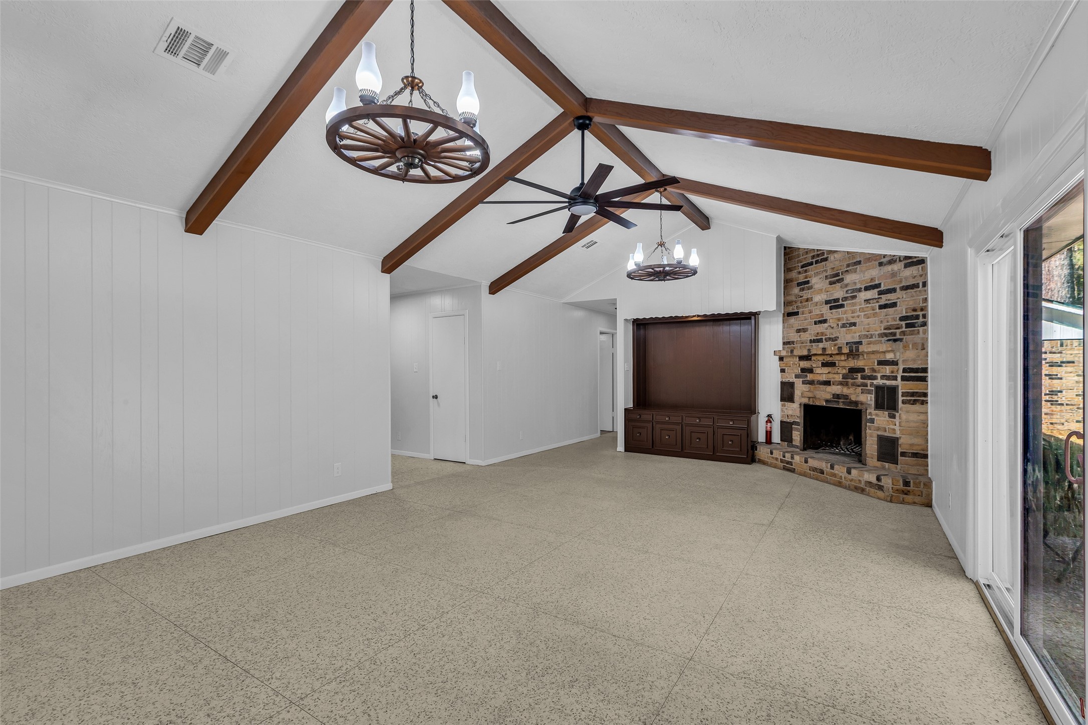 23311 Nichols Sawmill Road Hockley, TX 77447 - Photo 4 of 23 an empty room with a fireplace and a chandelier