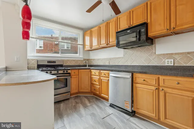 a kitchen with stainless steel appliances granite countertop a sink and a stove