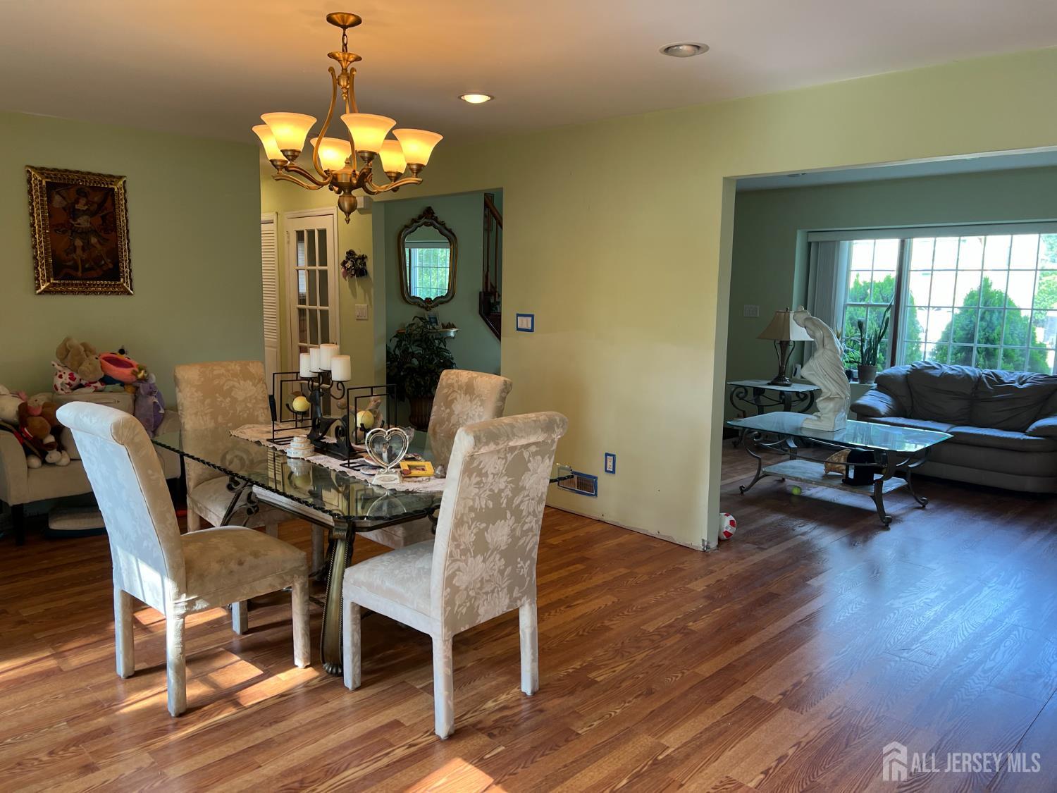 105 Howard Avenue Edison, NJ 08837 - Photo 16 of 39 a view of a dining room with furniture a chandelier and wooden floor